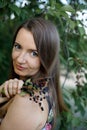 A beautiful Mature woman with long hair collects cherry berries from a tree. Everyday life of a European woman in the village Royalty Free Stock Photo