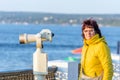 Beautiful mature woman looking through a telescope watching