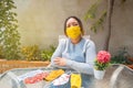 Beautiful mature woman sitting in the garden with her face masks. A very warm day. A concept of relaxation Royalty Free Stock Photo