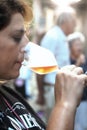 Woman tasting a glass of white sparklig wine. Color image