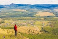 a beautiful mature woman stands on the top of Mount Kraka and looks into the distance at the Ural village of Shigaevo