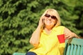 Beautiful mature woman talking on mobile phone in park Royalty Free Stock Photo