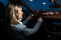 Beautiful mature woman thinking while driving her car for the city at night Royalty Free Stock Photo