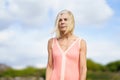 Beautiful mature woman walking along a wooden path near the beach., wearing a nice orange dress. Royalty Free Stock Photo