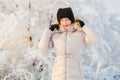 Beautiful Mature woman in white winter down jacket puts on hood in winter Royalty Free Stock Photo