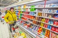 beautiful mature women with a grocery cart chooses products for a family in a supermarket.