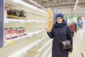 Beautiful mature women are surprised at the empty shelves in the supermarket after rush demand during the epidemic.