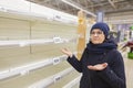 Beautiful mature women are surprised at the empty shelves in the supermarket after rush demand during the epidemic.