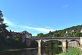 Beautiful medieval bridge across a river in a smal village of south of France. France vacations background.