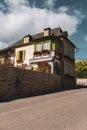 Beautiful medieval house with stone fence, garden and street lamp. Nice village street in France. Residential cottage with flowers Royalty Free Stock Photo