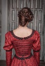 Beautiful medieval woman in red dress, back