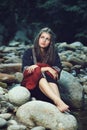 Beautiful medieval woman seated on rocks