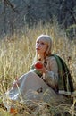 Beautiful medieval woman sitting on glade