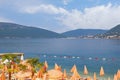 Beautiful Mediterranean landscape with beach umbrellas. Summer beach vacation. Montenegro. View of Bay of Kotor Royalty Free Stock Photo