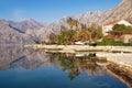 Beautiful Mediterranean landscape with mountains and town, reflected in water. Montenegro, Bay of Kotor, Dobrota town