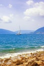 Beautiful Mediterranean landscape. One sailboat with white sail on water. Montenegro, Kotor Bay Royalty Free Stock Photo