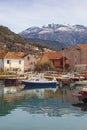 Beautiful Mediterranean landscape with small harbor for fishing boats.  Montenegro, Tivat city. Snow-capped Lovcen mountain Royalty Free Stock Photo