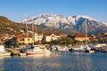 Beautiful Mediterranean landscape on sunny winter day. Fishing boats in harbor at foot of snowy mountains. Montenegro, Tivat Royalty Free Stock Photo