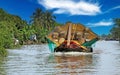 Beautiful Mekong Delta landscape, one traditional typical vietnamese sampan rice cargo boat, green palm trees - Mekong Delta,