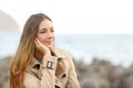 Beautiful melancholic woman thinking in winter on the beach