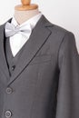 Beautiful men`s grey jacket suit with shirt and bow tie on white background Royalty Free Stock Photo