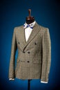 Beautiful men`s grey jacket suit with shirt and tie on a dummy or mannequin on blue background Royalty Free Stock Photo