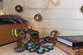 A beautiful mess on the table of a romantic girl: books, an Indian box with ancient ornaments, a small toy doll.