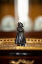 Beautiful metal antique figurine of a girl in a renaissance style interior