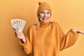 Beautiful middle age blonde woman holding 10 united kingdom pounds banknotes celebrating achievement with happy smile and winner