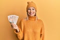 Beautiful middle age blonde woman holding 10 united kingdom pounds banknotes looking positive and happy standing and smiling with