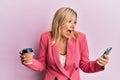 Beautiful middle age blonde woman using smartphone and drinking a cup of coffee celebrating crazy and amazed for success with open Royalty Free Stock Photo