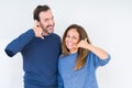 Beautiful middle age couple in love over isolated background smiling doing phone gesture with hand and fingers like talking on the Royalty Free Stock Photo