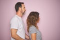 Beautiful middle age couple together standing over isolated pink background looking to side, relax profile pose with natural face Royalty Free Stock Photo