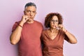 Beautiful middle age couple together wearing casual clothes mouth and lips shut as zip with fingers Royalty Free Stock Photo