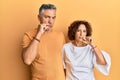 Beautiful middle age couple together wearing casual clothes mouth and lips shut as zip with fingers Royalty Free Stock Photo