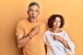 Beautiful middle age couple together wearing casual clothes surprised pointing with finger to the side, open mouth amazed Royalty Free Stock Photo