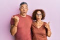 Beautiful middle age couple together wearing casual clothes surprised pointing with hand finger to the side, open mouth amazed Royalty Free Stock Photo