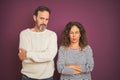 Beautiful middle age couple wearing winter sweater over isolated purple background skeptic and nervous, disapproving expression on Royalty Free Stock Photo