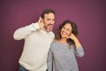 Beautiful middle age couple wearing winter sweater over isolated purple background smiling doing phone gesture with hand and Royalty Free Stock Photo