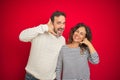 Beautiful middle age couple wearing winter sweater over isolated red background smiling doing phone gesture with hand and fingers Royalty Free Stock Photo