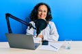 Beautiful middle age doctor woman working at radio studio happy face smiling with crossed arms looking at the camera Royalty Free Stock Photo