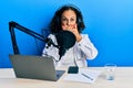 Beautiful middle age doctor woman working at radio studio shocked covering mouth with hands for mistake Royalty Free Stock Photo