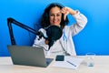 Beautiful middle age doctor woman working at radio studio smiling making frame with hands and fingers with happy face Royalty Free Stock Photo