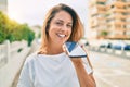 Beautiful middle age hispanic woman smiling sending a voice message on the phone happy outdoors Royalty Free Stock Photo