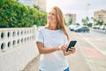 Beautiful middle age hispanic woman smiling using smatphone happy outdoors Royalty Free Stock Photo