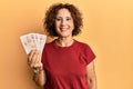Beautiful middle age mature woman holding 10 united kingdom pounds banknotes looking positive and happy standing and smiling with