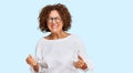Beautiful middle age mature woman wearing casual clothes and glasses very happy and excited doing winner gesture with arms raised, Royalty Free Stock Photo
