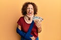 Beautiful middle age mature woman wearing cervical collar and sling holding insurance euros smiling and laughing hard out loud Royalty Free Stock Photo