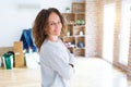 Beautiful middle age woman with curly hair smiling confident at new home, renovating and painting house Royalty Free Stock Photo