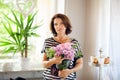 Beautiful middle age woman decorating home with flowers Royalty Free Stock Photo